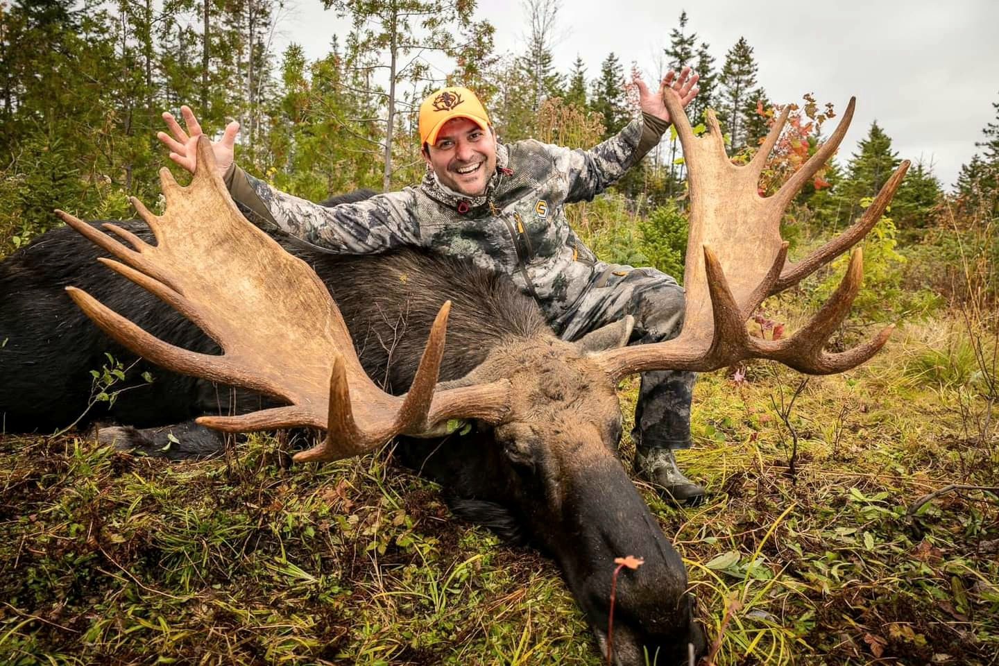 Hunter posing with a harvested moose.