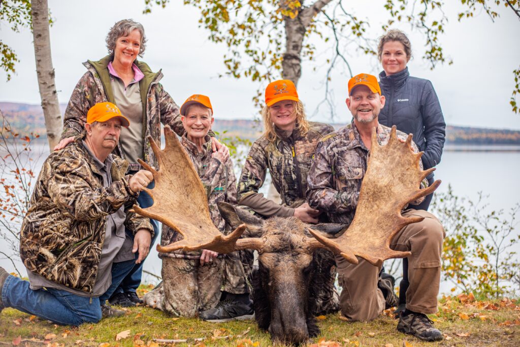 Group of hunters posing with a moose.