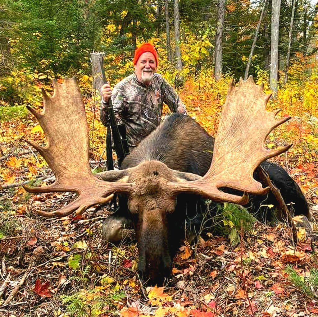 A hunter poses with a large bull moose.