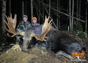 Two hunters with a large moose.